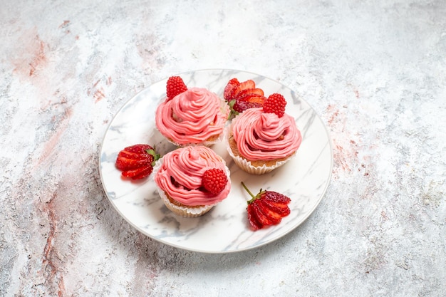 Foto gratuita torte di fragola rosa vista frontale con fragole rosse fresche su uno spazio bianco