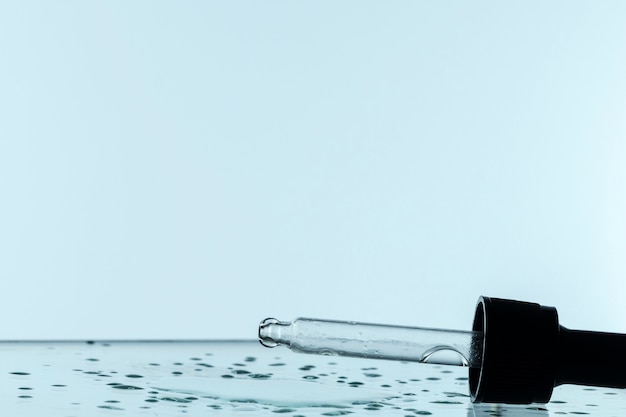 Free photo front view of pipette with liquid drops and copy space