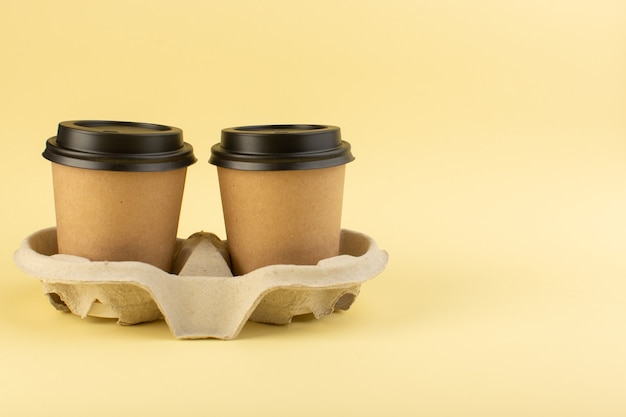 A front view plastic coffee cups delivery coffee pair on the yellow wall