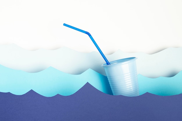 Front view of plastic cup with straw and paper waves