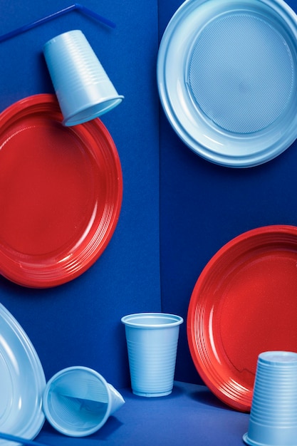 Вид спереди на пластиковые тарелки и чашки
