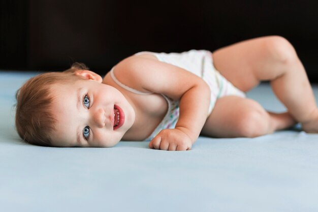 Front view of playful baby in bed