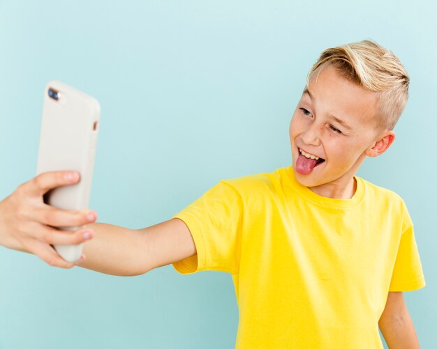 Front view playful boy taking selfie