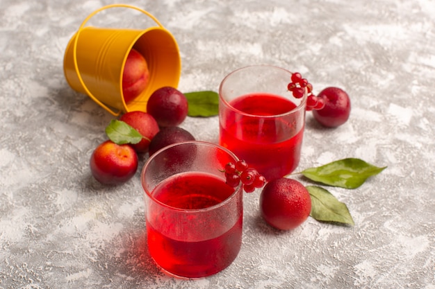 Free photo front view plum juice red colored with fresh plums on grey