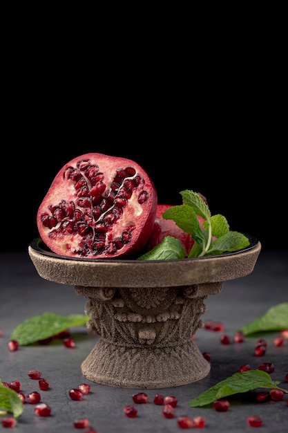 Free photo front view of pomegranate on display with mint