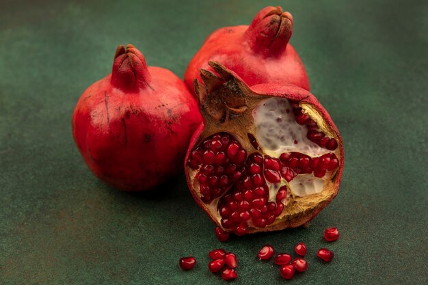 Front view pomegranate halves on green wall