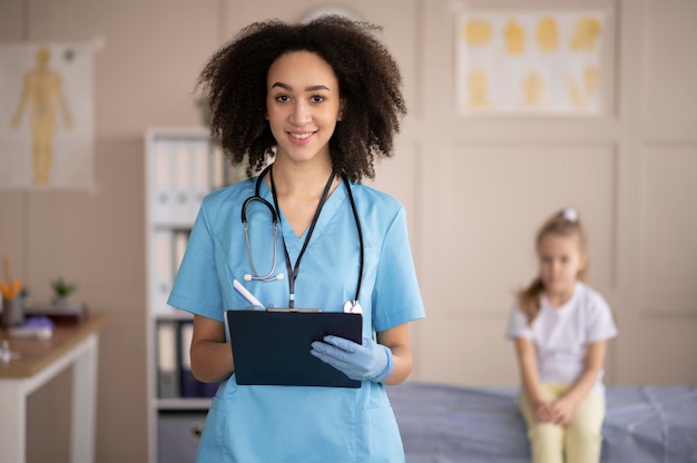 Foto gratuita ritratto di vista frontale del medico accanto alla piccola ragazza paziente