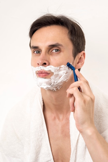 Front view portrait of man shaving 