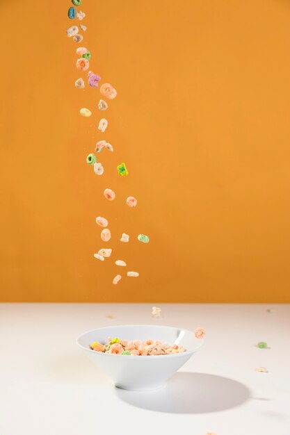 Front view pouring cereals on bowl from table