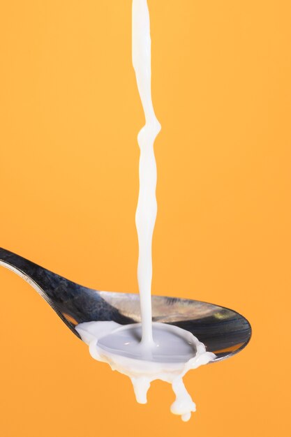 Front view pouring milk on spoon process