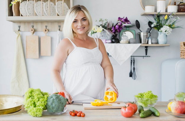 Front view pregnant woman in the kitchen 