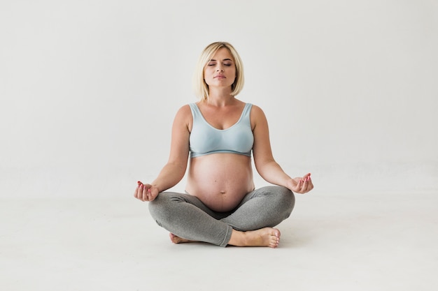 Front view pregnant woman meditating 