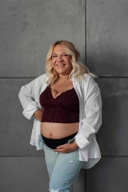 Free photo front view pregnant woman posing in studio