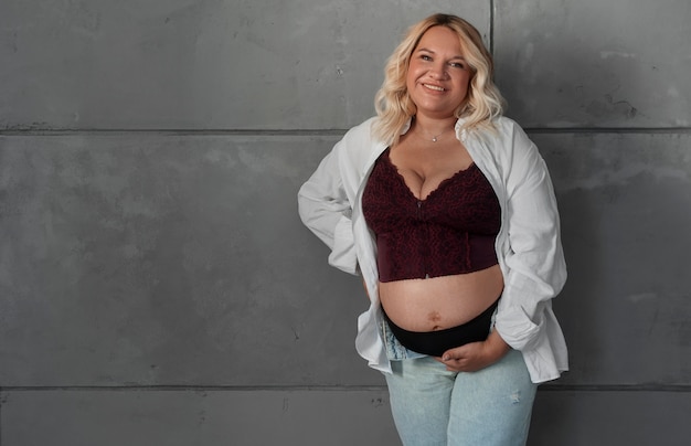 Free photo front view pregnant woman posing in studio