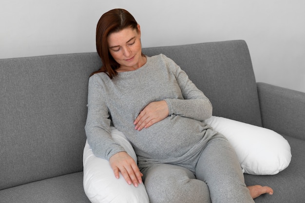 Foto gratuita donna incinta di vista frontale che si rilassa a casa