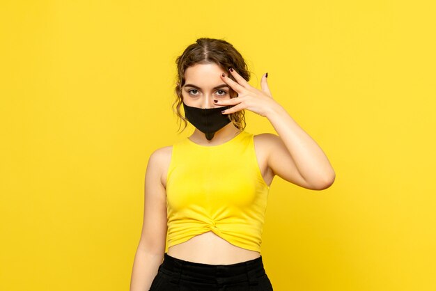 黄色の黒いマスクのきれいな女性の正面図
