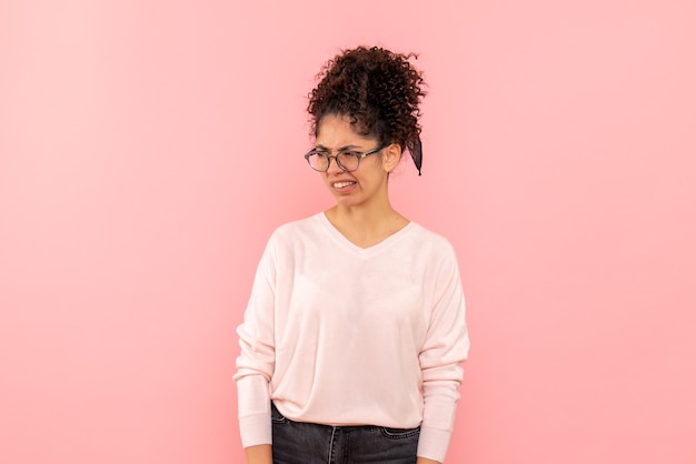 Front view of pretty female displeased on pink