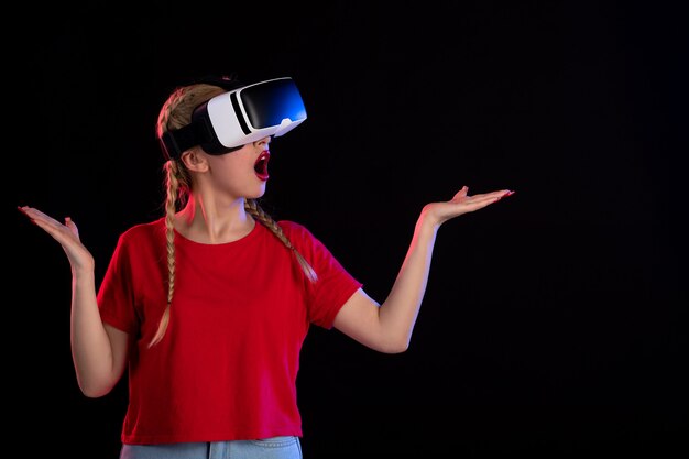 Front view of pretty female excitedly playing vr on a dark  ultrasound fantasy games d