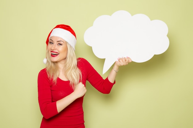 Front view pretty female holding cloud shaped white sign on green wall emotion snow new year holidays christmas