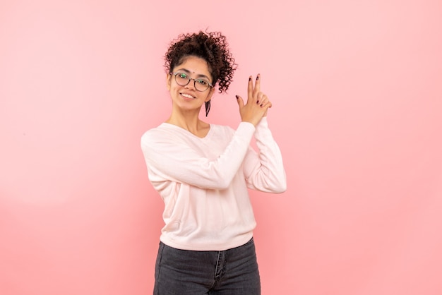 Free photo front view of pretty female imitating gun holding on pink