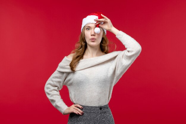 Front view of pretty female playing with red cap on red