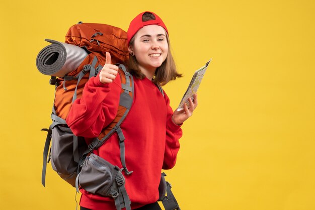 Front view pretty female traveler with backpack holding map giving thumbs up