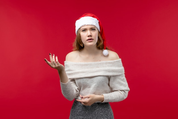 Front view of pretty female with confused face on red