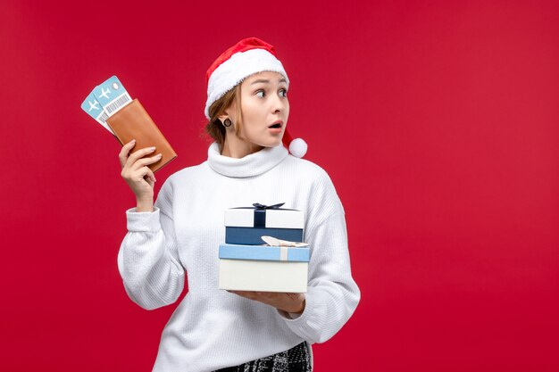 Front view pretty female with tickets presents on red background