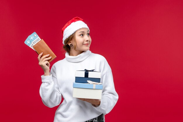 Front view pretty female with tickets presents on red desk