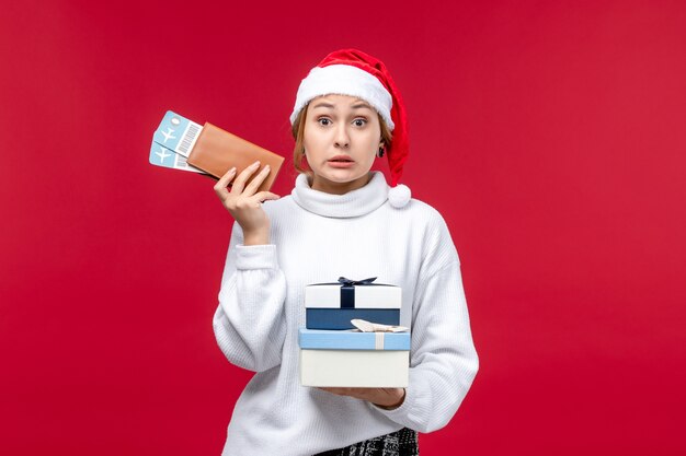 Front view pretty lady with tickets and presents on a red background