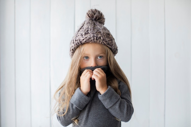 Free photo front view pretty little girl covering her face