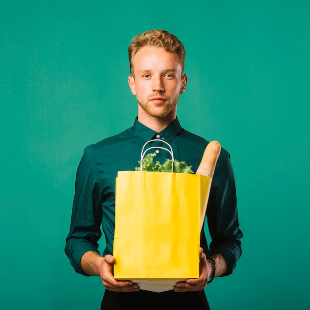 Free photo front view pretty man holding groceries bag