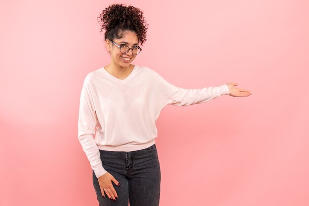 Front view of pretty woman on light pink wall