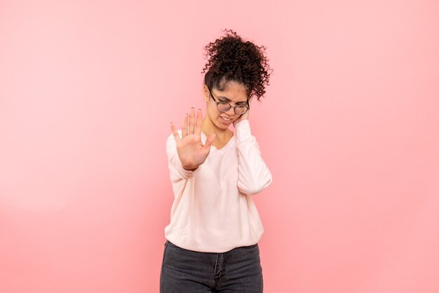 Front view of pretty woman with hurt ear on pink wall