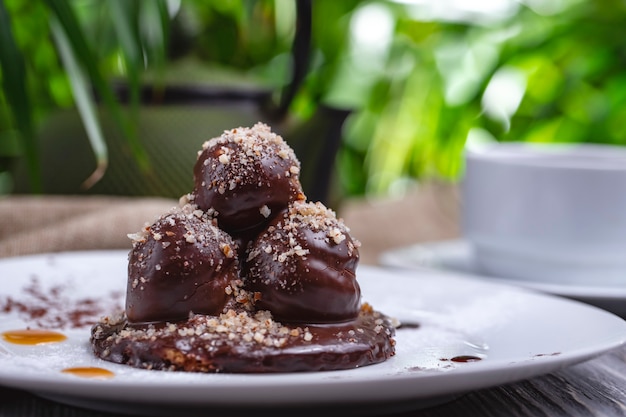 Front view profiteroles in chocolate icing and nuts