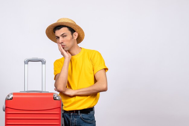 Front view prying young man with yellow t-shirt and straw hat