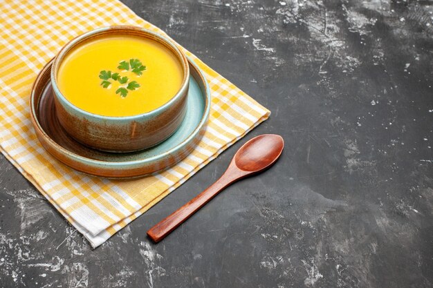 Вид спереди тыквенный суп внутри тарелки на темном столе