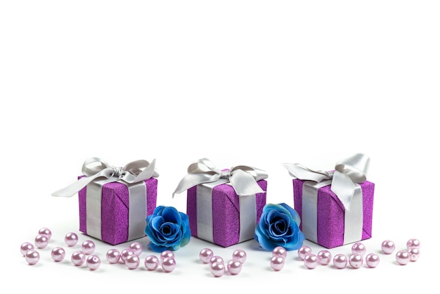 Фиолетовые подарочные коробки с серыми бантами на белом столе, вид спереди