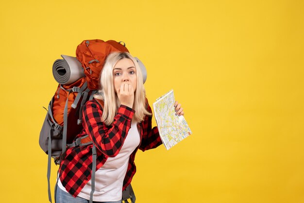 Вид спереди озадаченная блондинка с рюкзаком, держащим карту