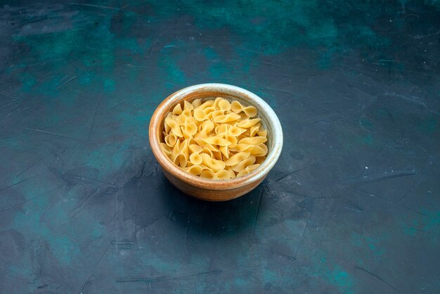 Front view raw italian pasta on blue desk