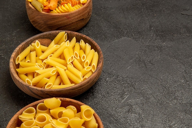 Front View Raw Italian Pasta Different Formed Inside Plates on a Grey Space – Free Download