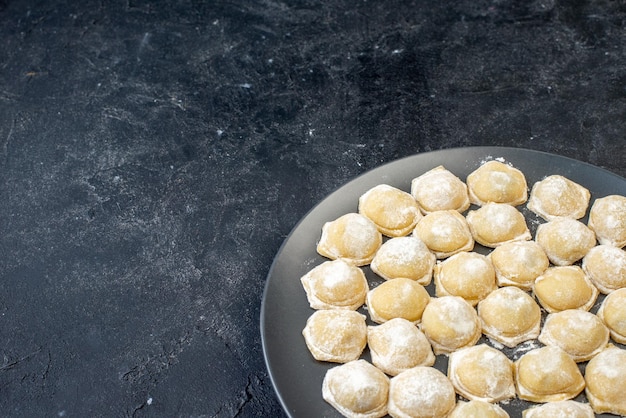 Free photo front view raw little dough with flour on dark background photo color cake hotcake biscuit dough dumpling pies bun