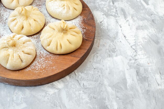 Front view raw little dumplings on a white background pie color bake cake salad meat food dough free space