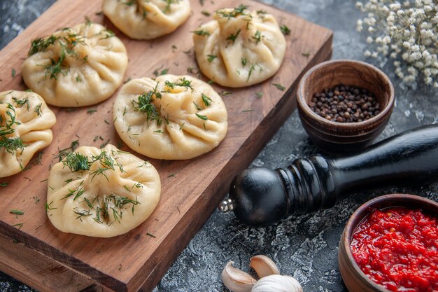 Front view raw little dumplings with meat on gray surface dough meal cake dinner cuisine meat cooking dish