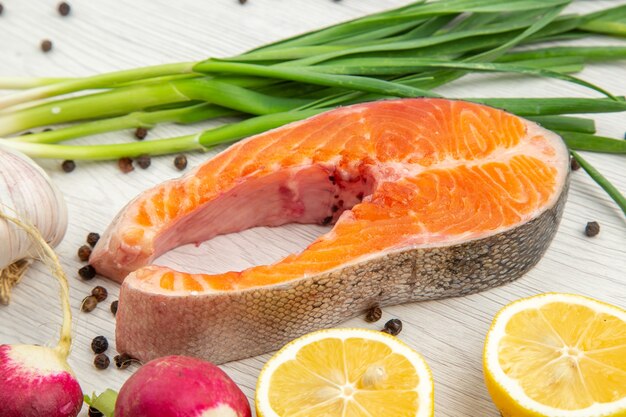 Front view raw meat slice with greens radish and garlic on white background food animal rib dish  meal fish