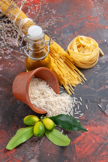 Front view raw pasta with rice and oil on dark surface raw dough pasta