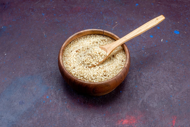 Front view raw product inside brown round pot on dark background