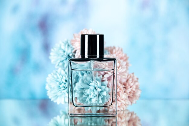 Front view of rectangle perfume bottle and flowers on blue blurred