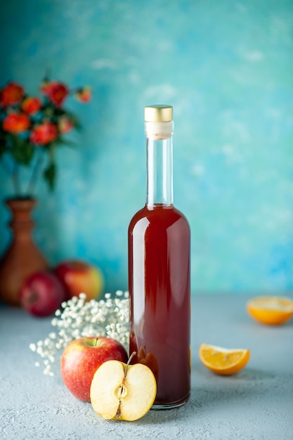 正面図青い壁に赤いリンゴ酢食べ物飲み物果物アルコールワイン酸っぱい色のジュース