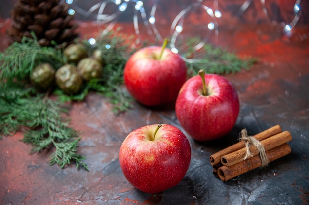 Free photo front view red apples cinnamon sticks on dark